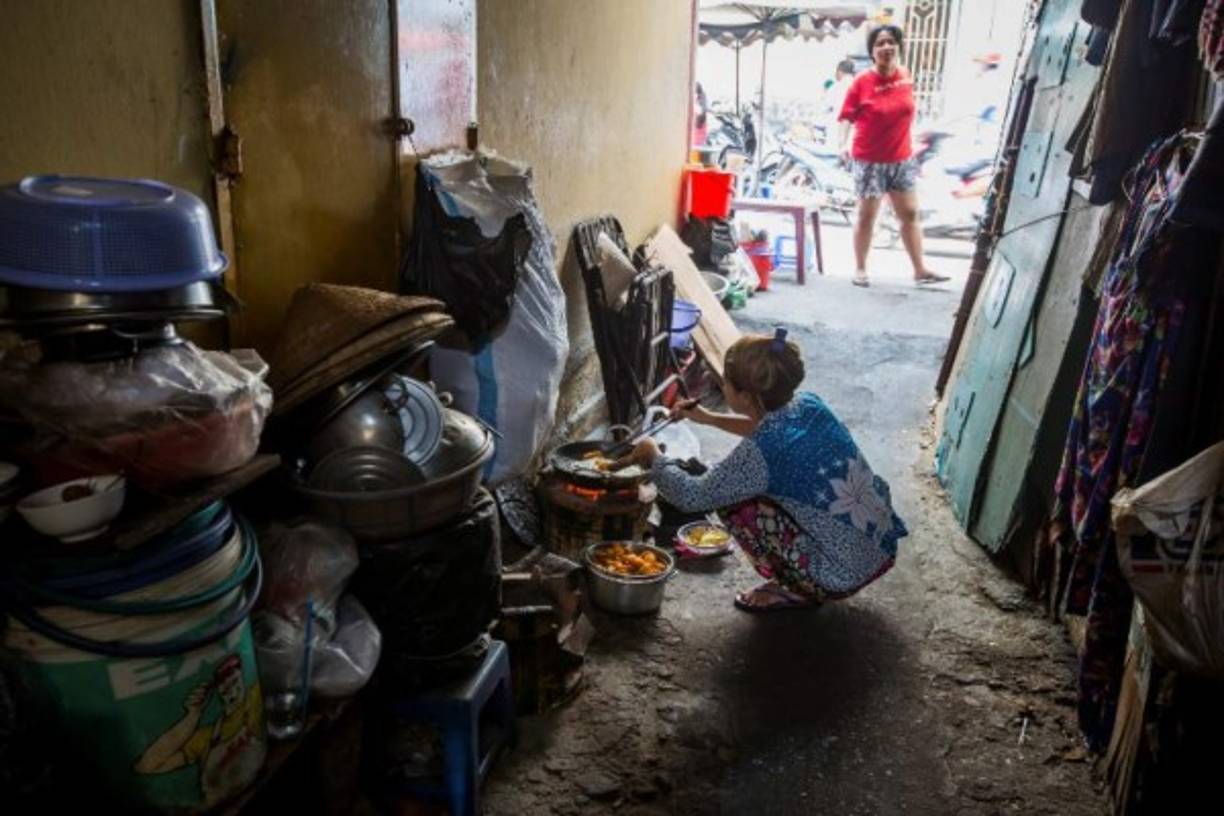 Las mujeres cocinan la comida para sus familias en el piso o en la calle.
