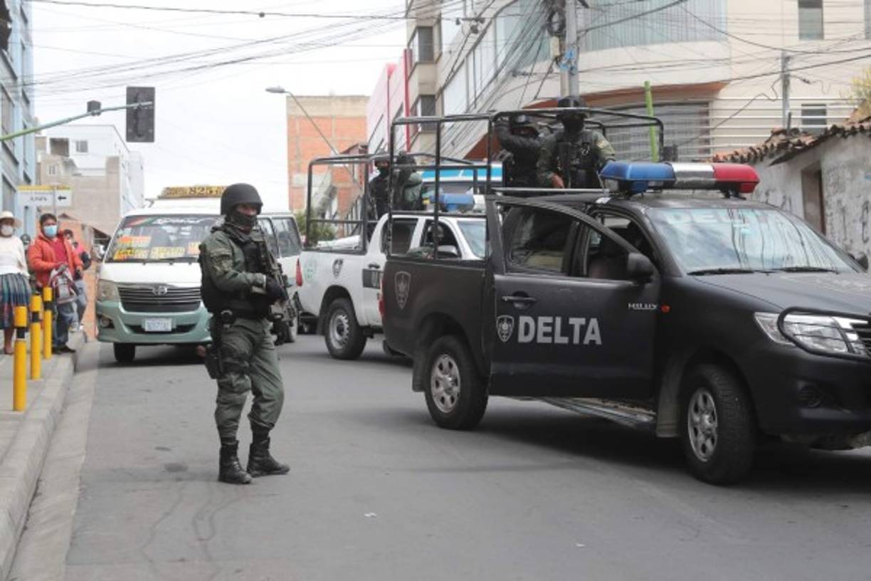 Miembros del grupo Delta de la policía custodian a la expresidenta transitoria de Bolivia Jeanine Áñez en La Paz, ante la mirada de cientos de bolivianos.