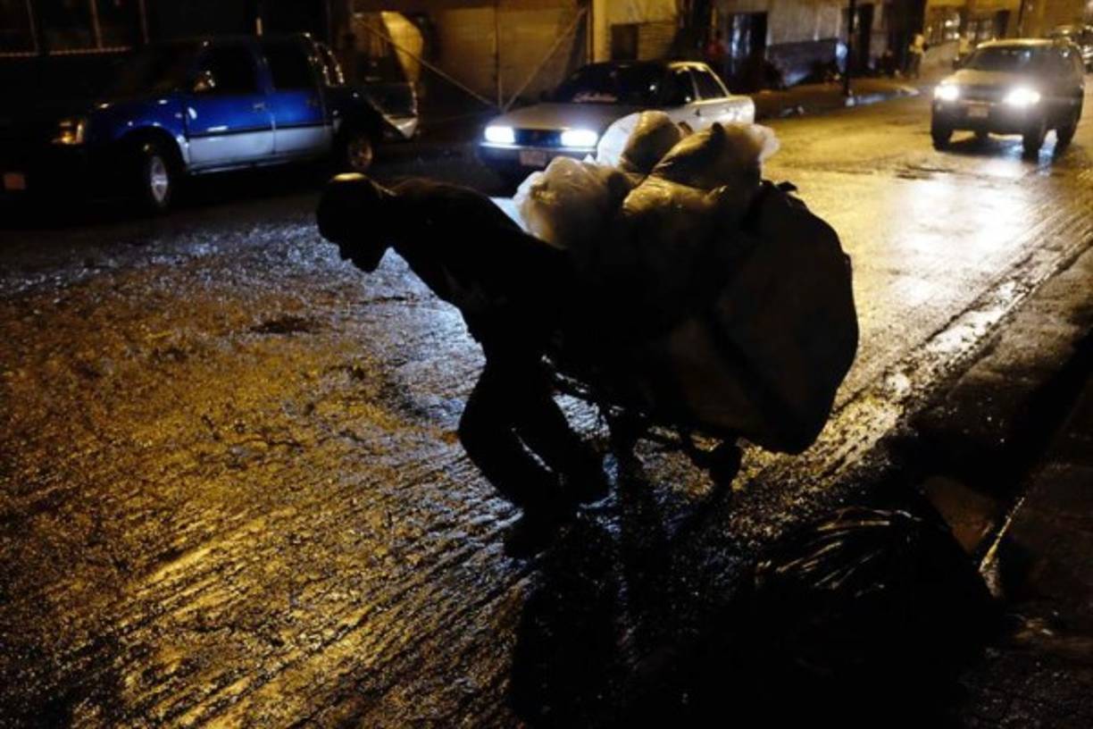 Un cartonero que con cargas de hasta de 150 kilos, llega a recorrer distancias hasta de 10 kilómetros en San José (Costa Rica). Mucho del material recolectado por los 'cartoneros' es ordenado y separado para su reciclaje. Invisibles ante los ojos de los transeúntes citadinos, los 'cartoneros', en su mayoría indigentes, al ritmo de las hormigas de trabajo recolectan los cartones desperdigados de los comercios de la capital en San José, Costa Rica. La suma del material recopilado por los cartoneros puede ascender a 8 toneladas diarias, según comenta Víctor Calvo, propietario del centro de reciclaje donde se realiza el acopio de los desechos en San José. Con una paga por kilo de 35 colones ($0,06), se convierte en un pequeño ingreso para estas personas que en su mayoría son dependientes de las drogas y que por esta labor muchos han dejado de robar. EFE/Jeffrey Arguedas.<br/>