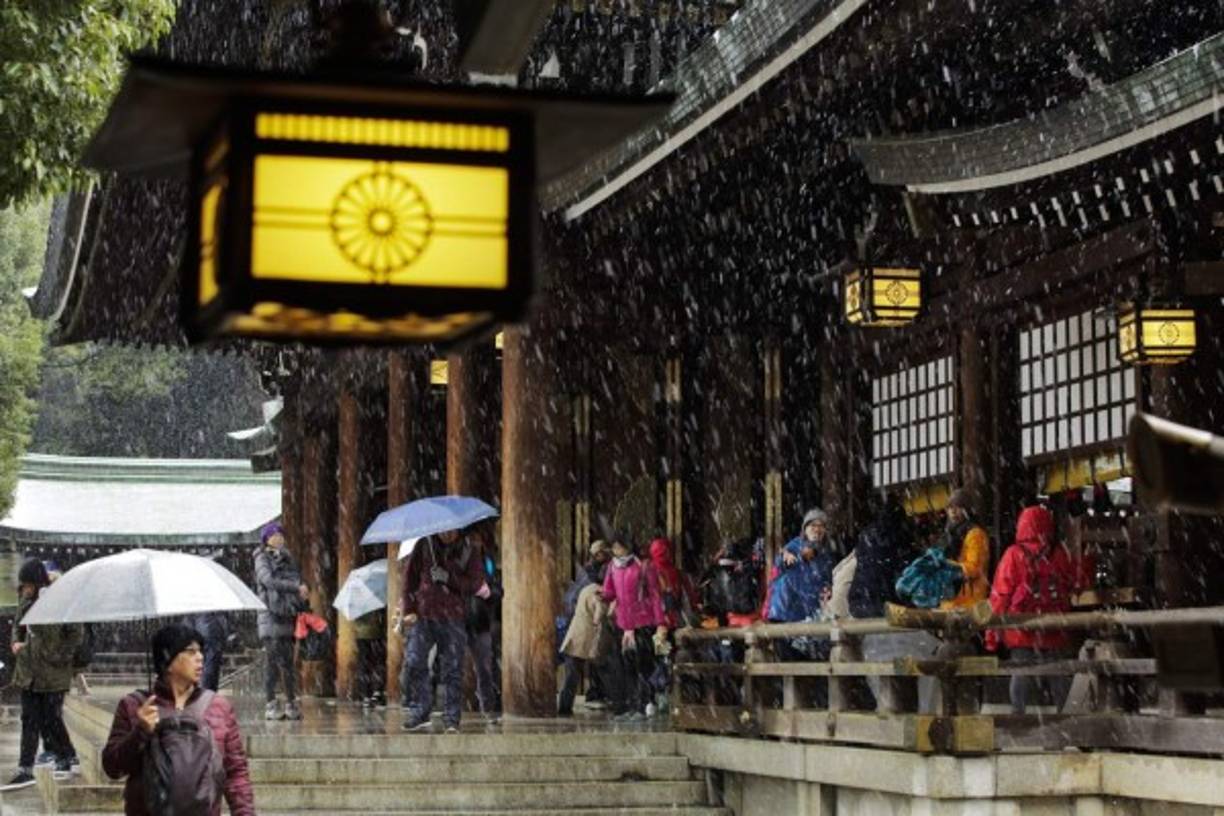 JAPÓN. Nieve llega en noviembre a Tokio. Turistas bajo la nieve de Tokio junto al templo Meiji, la nieve cae en la ciudad por primera vez en noviembre en 54 años. Foto: EFE/Kimimasa Mayama
