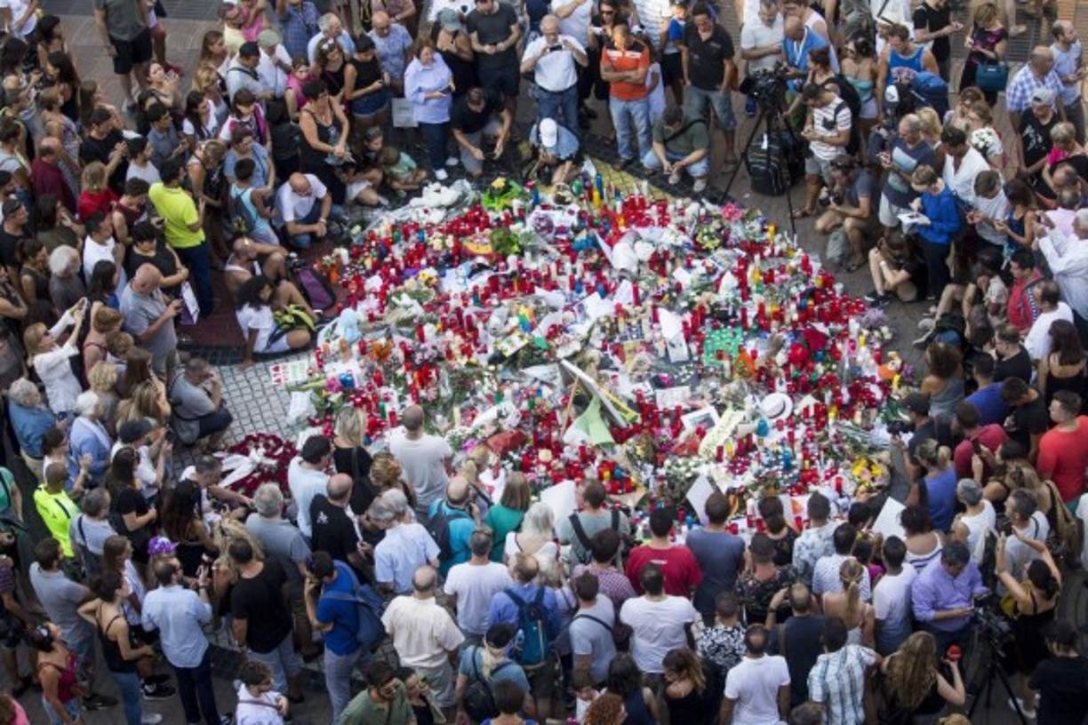 Cientos de ciudadanos se han acercado a Las Ramblas para dejar flores y velas encendidas en un punto de la calzada central, situado frente al Teatre del Liceu, sobre un cartel con el lema 'Catalunya, lloc de pau' ('Cataluña, lugar de paz'). EFE