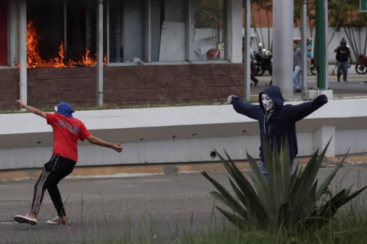 Simpatizantes del Partido Libertad y Refundación queman una farmacia cuando se enfrentan a la policía durante una nueva jornada de protesta en contra del presidente de Honduras, Juan Orlando Hernández, en Tegucigalpa (Honduras). EFE