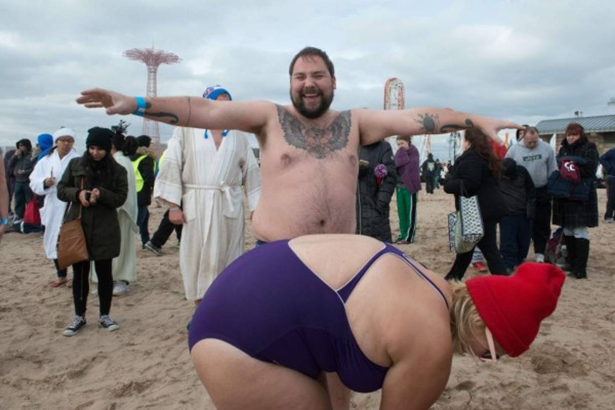 People in bathing suits run into the ocean during the annual Coney Island Polar Bear Club New Year's Day swim on January 1, 2016 in the Brooklyn borough of New York City.
