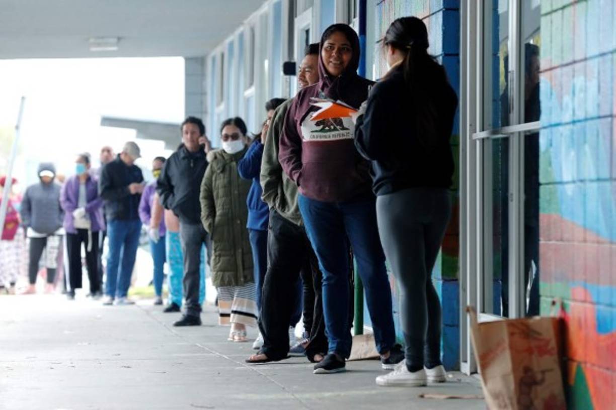 Residentes esperam por alimentos entregados por Second Harvest de Silicon Valley en el estacionamiento del Boys and Girls Club en el sur de San Francisco, California. EFE