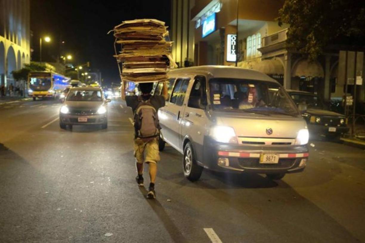 Un hombre que camina con una carga de 60 kilos de cartones en San José (Costa Rica). Mucho del material recolectado por los 'cartoneros' es ordenado y separado para su reciclaje. Invisibles ante los ojos de los transeúntes citadinos, los 'cartoneros', en su mayoría indigentes, al ritmo de las hormigas de trabajo recolectan los cartones desperdigados de los comercios de la capital en San José, Costa Rica. La suma del material recopilado por los cartoneros puede ascender a 8 toneladas diarias, según comenta Víctor Calvo, propietario del centro de reciclaje donde se realiza el acopio de los desechos en San José. Con una paga por kilo de 35 colones ($0,06), se convierte en un pequeño ingreso para estas personas que en su mayoría son dependientes de las drogas y que por esta labor muchos han dejado de robar. EFE/Jeffrey Arguedas<br/>
