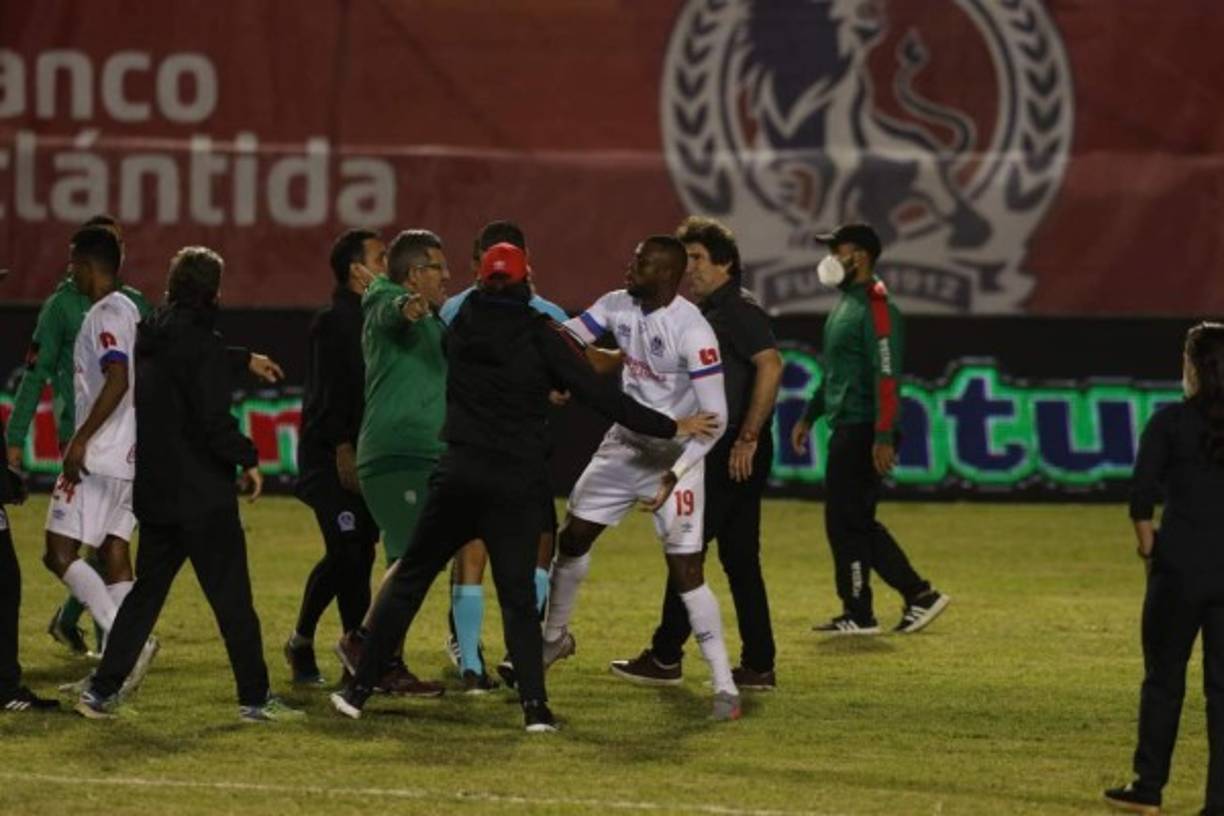 Yustin Arboleda tratando de controlar un miembro del cuerpo técnico del Marathón.