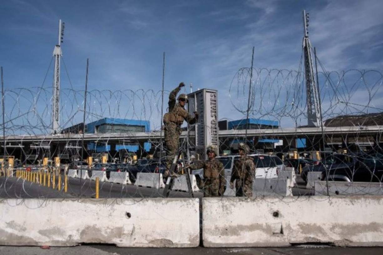 US Department of Defence personnel install barriers requested by Custom and Border Protection at the San Ysidro port of entry, San Diego, US, under the Operation Secure Line anticipating the arrival of Central American migrants heading towards the border, as seen from the Mexican side of the border in Tijuana, Mexico, on November 13, 2018. - US Defence Secretary Jim Mattis said Tuesday he will visit the US-Mexico border, where thousands of active-duty soldiers have been deployed to help border police prepare for the arrival of a 'caravan' of migrants. (Photo by GUILLERMO ARIAS / AFP)