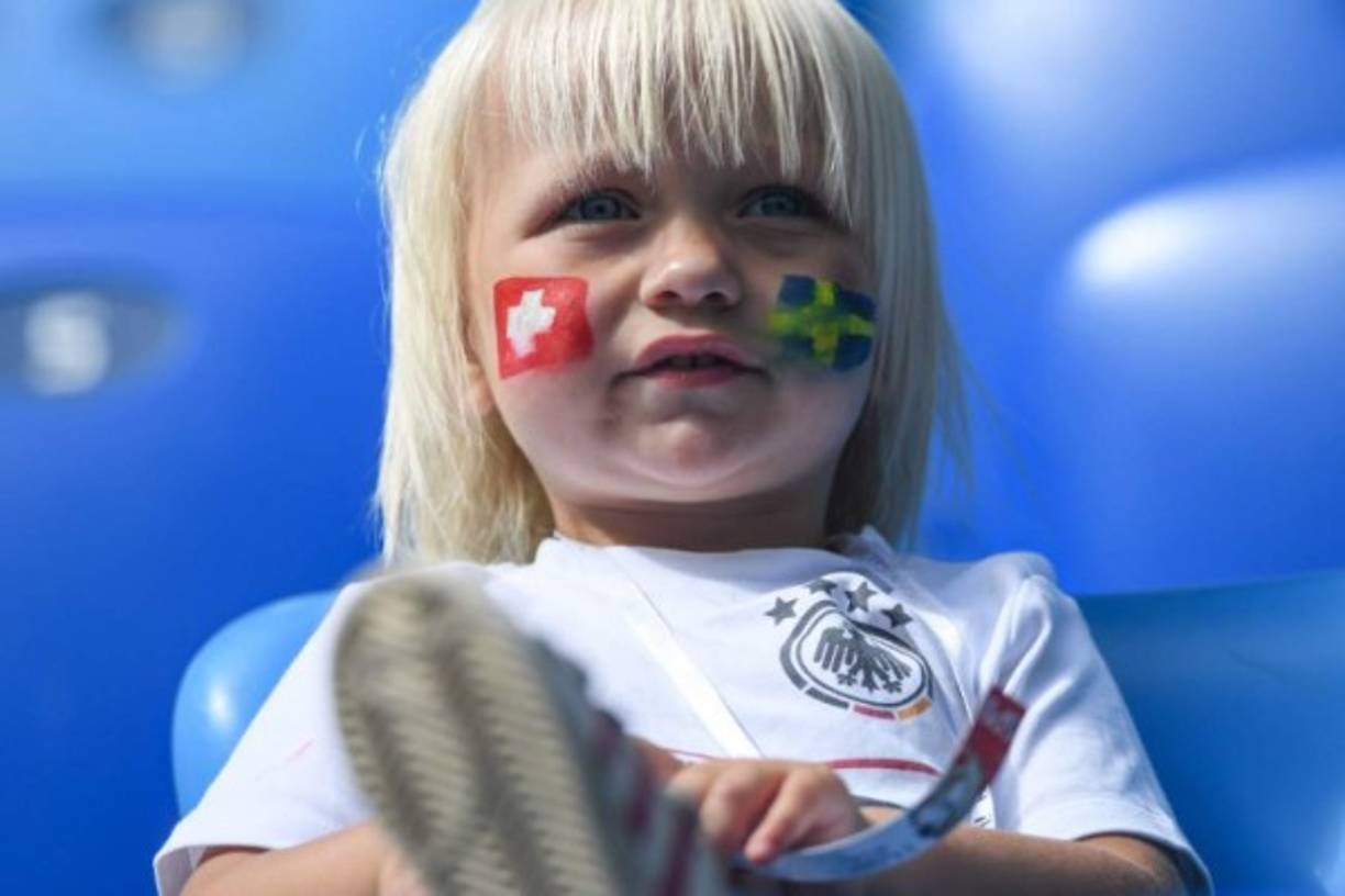 Un pequeño espera por el partido con las banderas de los dos países en su rostro. Foto AFP