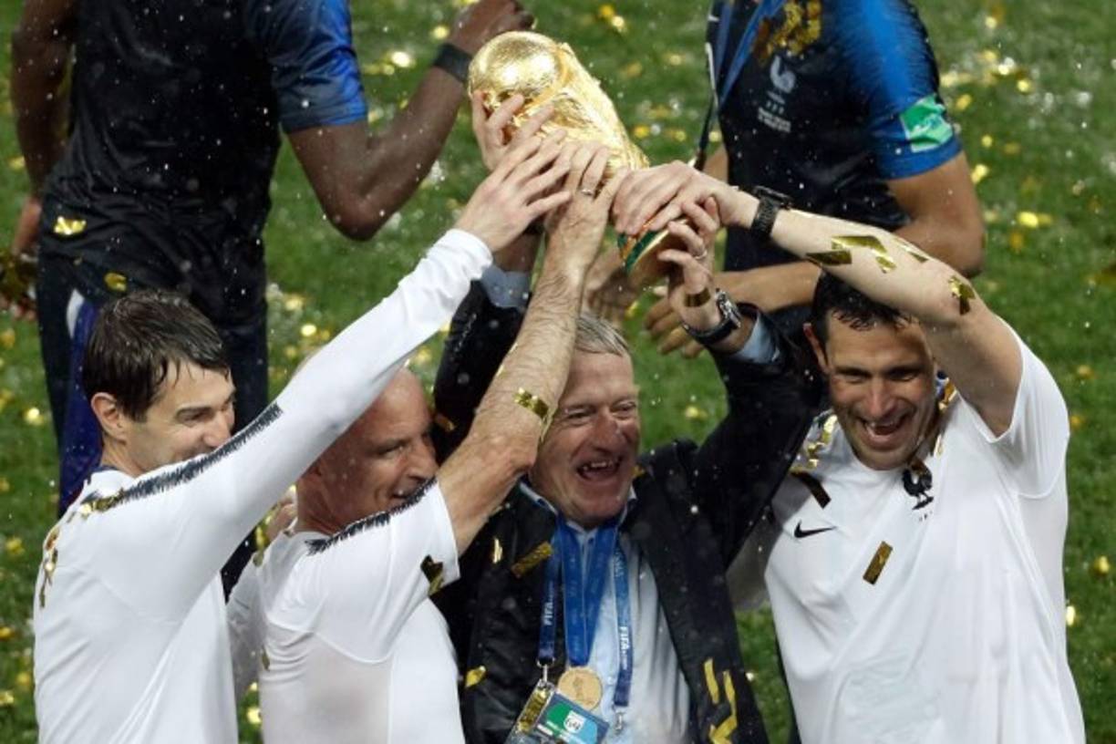 Didier Deschamps levantando el trofeo de campeón del mundo con su cuerpo técnico.