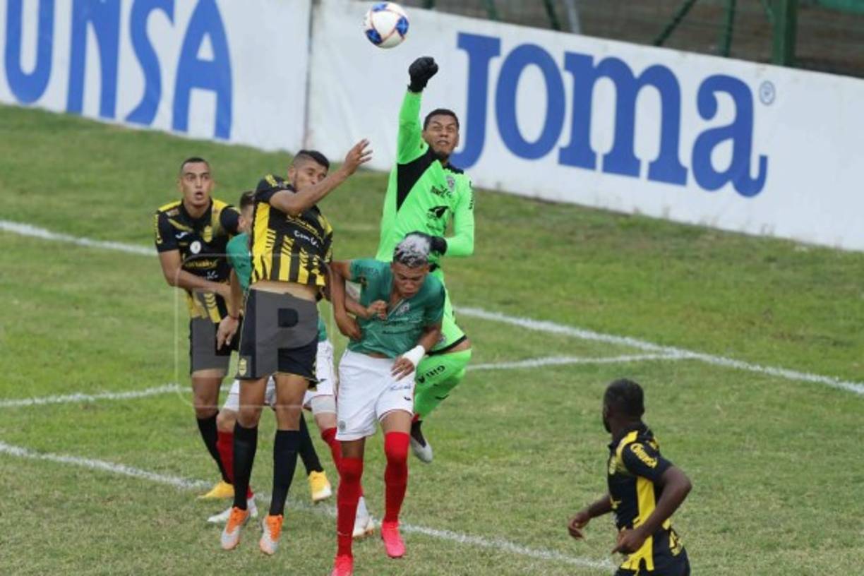 Denovan Torres despeja el balón con su puño derecho.