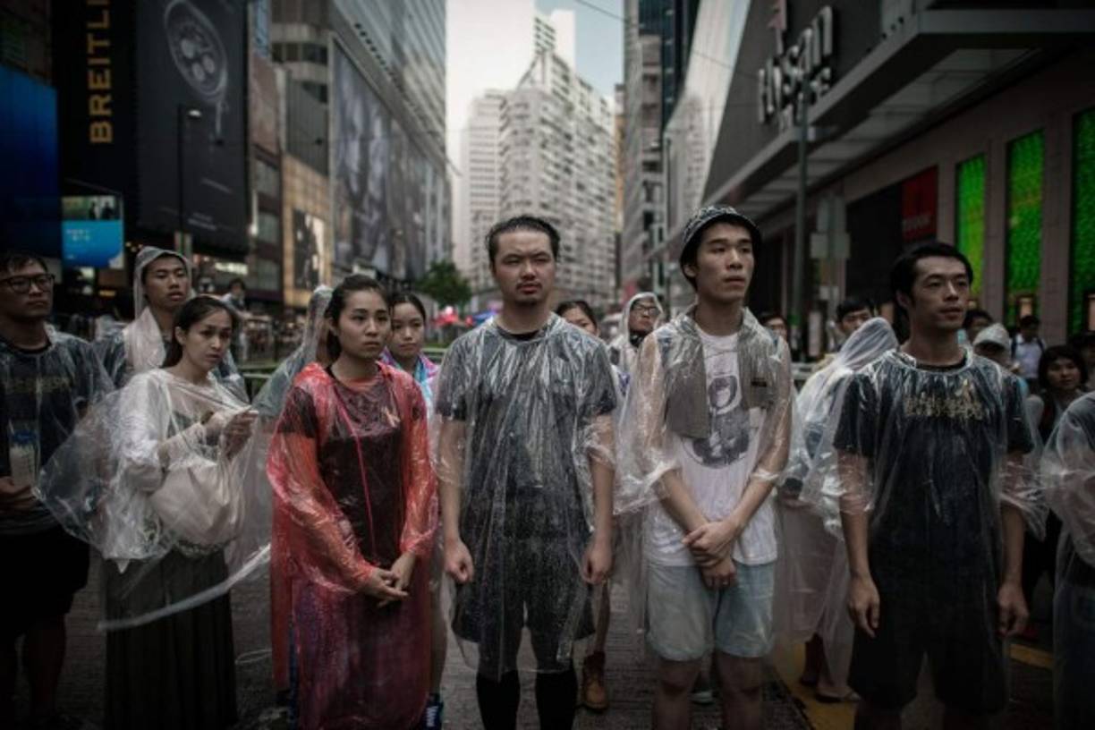 Manifestantes prodemocráticos observan mientras protegen una barricada de anti-manifestantes en una zona ocupada de Hong Kong el 3 de octubre de 2014. AFP