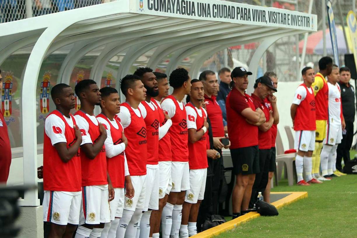 Jugadores suplentes del Olimpia mientras sonaba el himno nacional de Honduras.