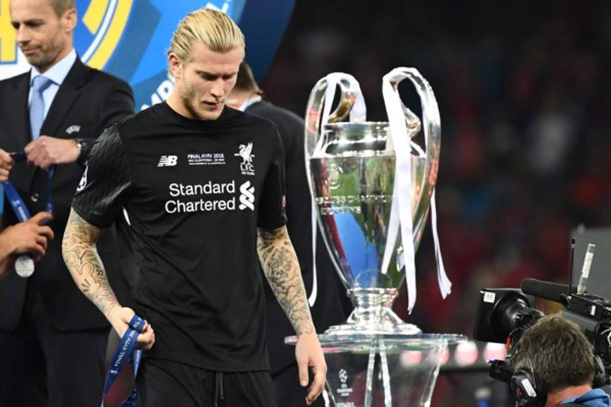 Liverpool's German goalkeeper Loris Karius walks past the trophy after losing the UEFA Champions League final football match between Liverpool and Real Madrid at the Olympic Stadium in Kiev, Ukraine, on May 26, 2018. / AFP PHOTO / FRANCK FIFE