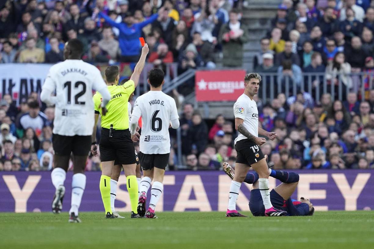 El árbitro Javier Alberola Rojas le muestra la tarjeta roja a Ronald Araújo que se lamentó en el suelo.