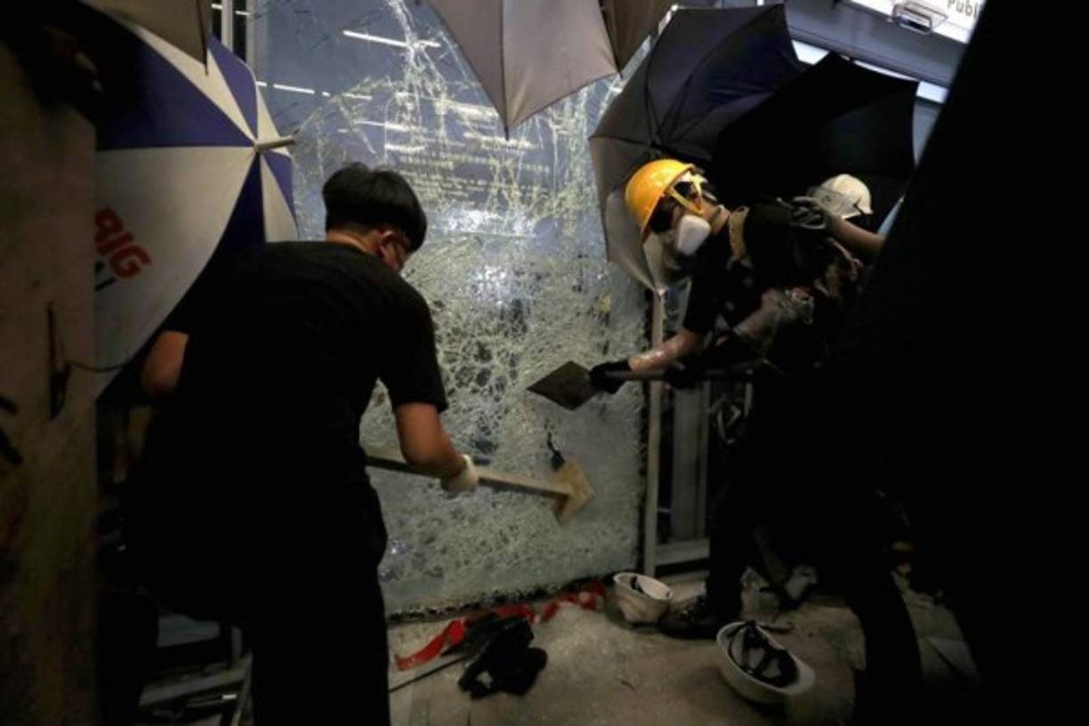 Decenas de personas enmascaradas irrumpieron en los recintos tras abrirse paso en el edificio rompiendo ventanas de vidrio, cantando consignas y pintando de negro el escudo de la ciudad.