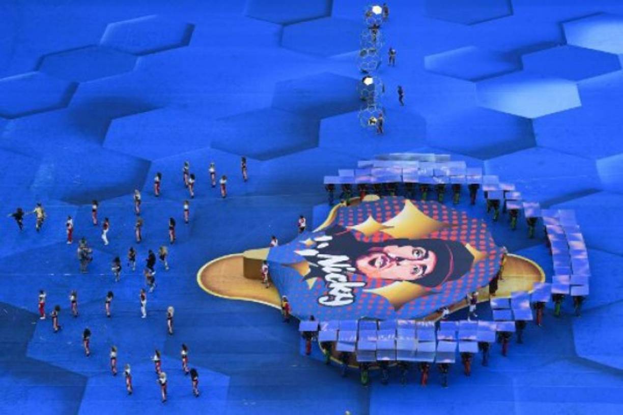 Sobre una lona azul que cubría todo el terreno de juego, con un gran escenario central dorado, un numeroso grupo de bailarines con llamativas ropas de colores con las banderas de los 32 países participantes bailaban al ritmo de la música de Nicky Jam.