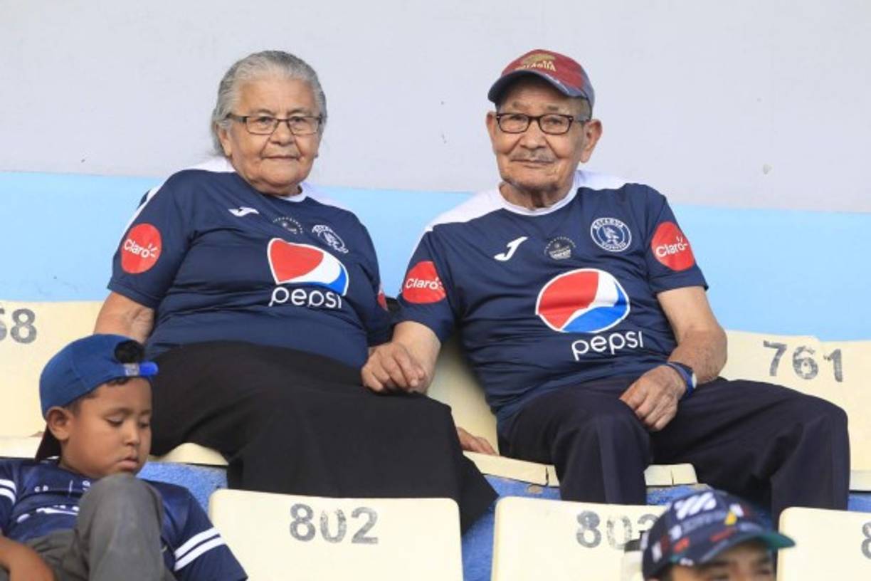 Dos aficionados longevos del Motagua apoyando a su equipo en el estadio Nacional contra el Real España.