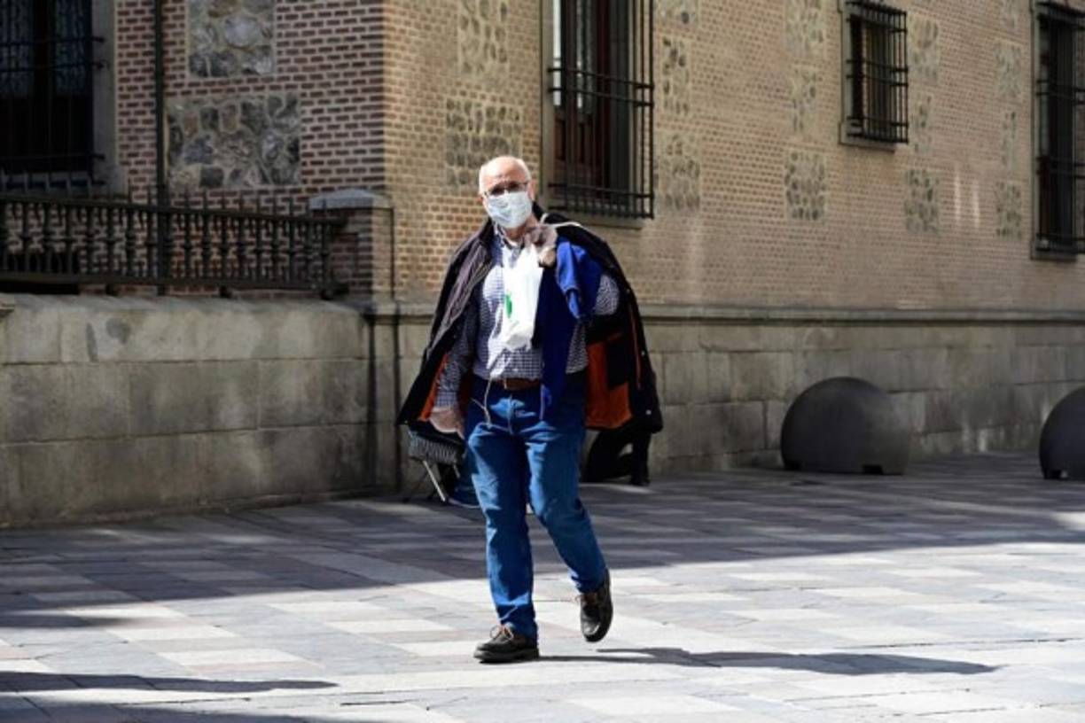 Trabajadores y ciudadanos con bolsas de la compra predominan en calles madrileñas inusualmente vacías en esta soleada mañana.