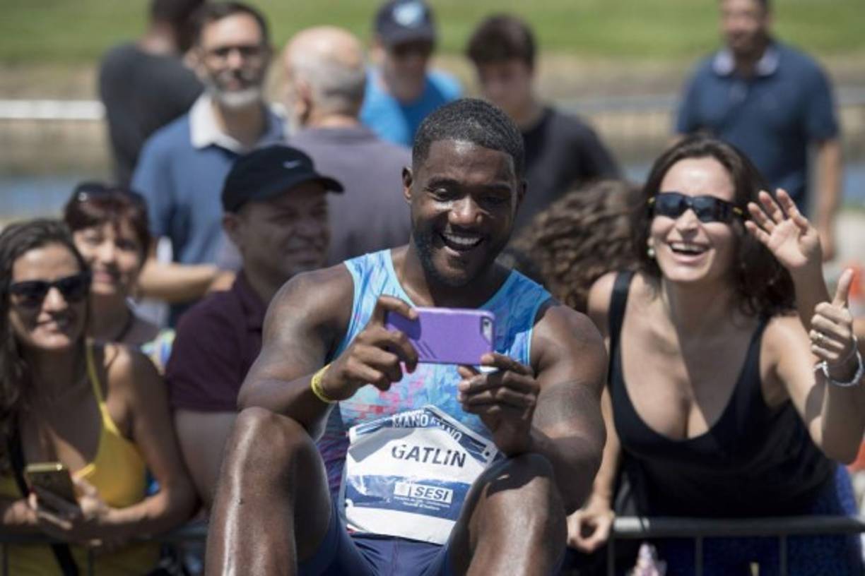 ATLETISMO. Selfi con la gente. El atleta estadounidense Justin Gatlin se toma una selfi con un grupo de aficionados después de ganar la final de los 100 metros del desafío de atletismo mano a mano en el Jockey Club Brasileiro de Río de Janeiro, Brasil.