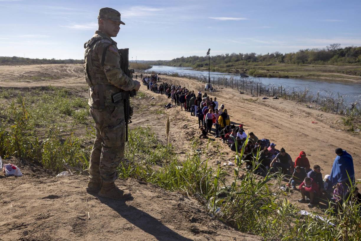 La Guardia Nacional de Texas supervisa una fila de migrantes a la espera de ser procesados por los agentes fronterizos.