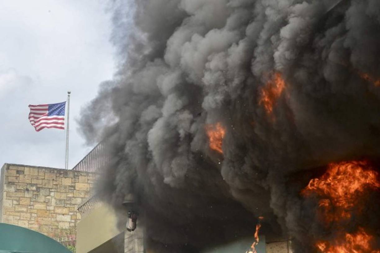 Gran cantidad de llantas fueron acumuladas en el acceso principal y segundos después las grandes puertas de la sede diplomática estadounidense ardían en llamas.