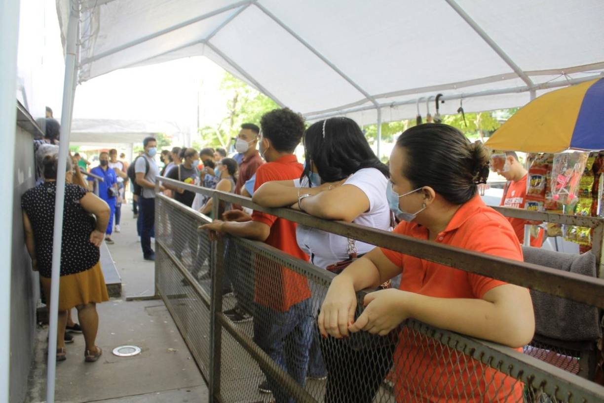 Largas filas de personas que van en busca de la cédula de identidad esperan bajo las carpas afuera del RNP.