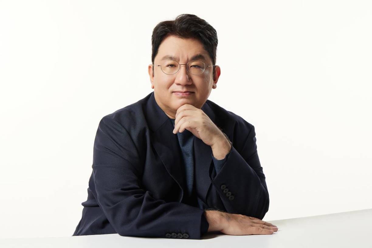 Ador fue fundado a medida para la propia Min Hee-jin en 2021 a voluntad de Bang Si-hyuk, presidente de Hybe, que había fichado en 2019 por todo lo alto a la entonces directora creativa en SM Entertainment, agencia rival y considerada una de las tres corporaciones primigenias de la música pop surcoreana.