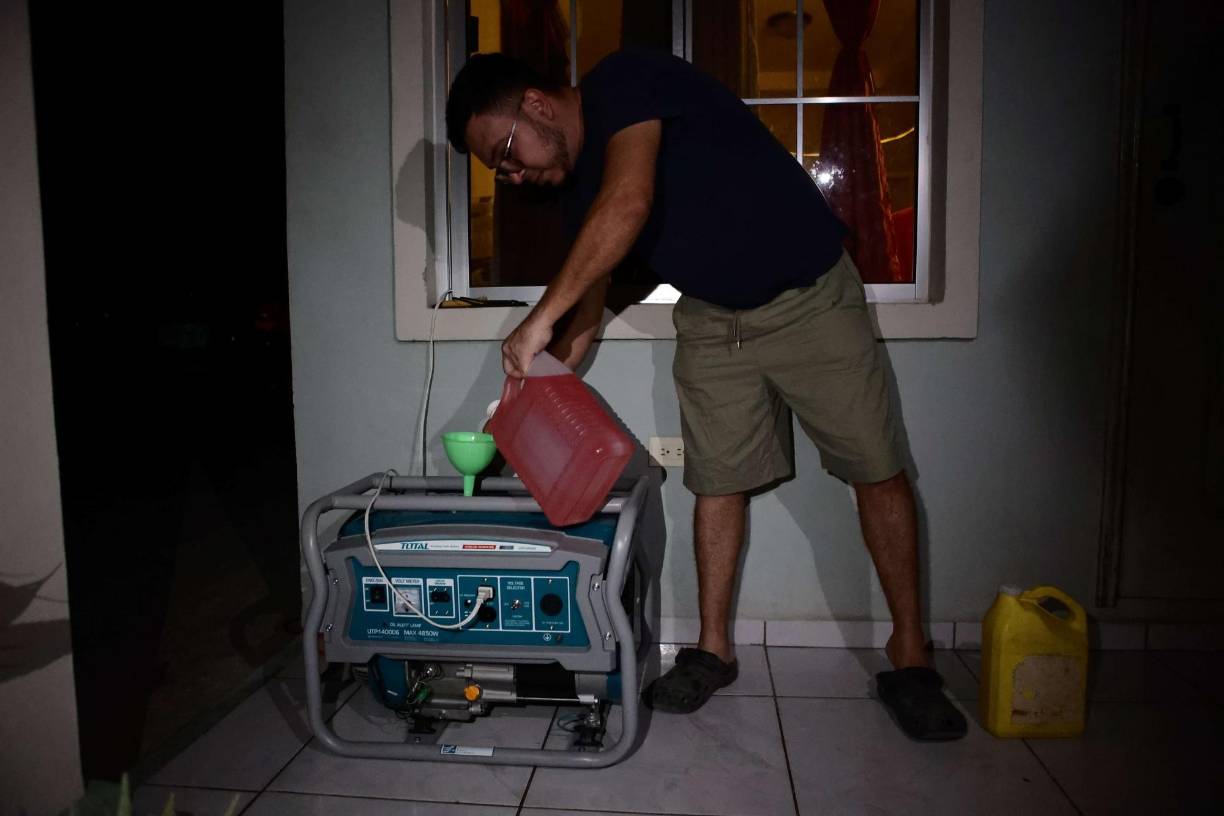 Uno de los vecinos pone a funcionar una planta eléctrica que compró recientemente a raíz de los apagones en su residencia.