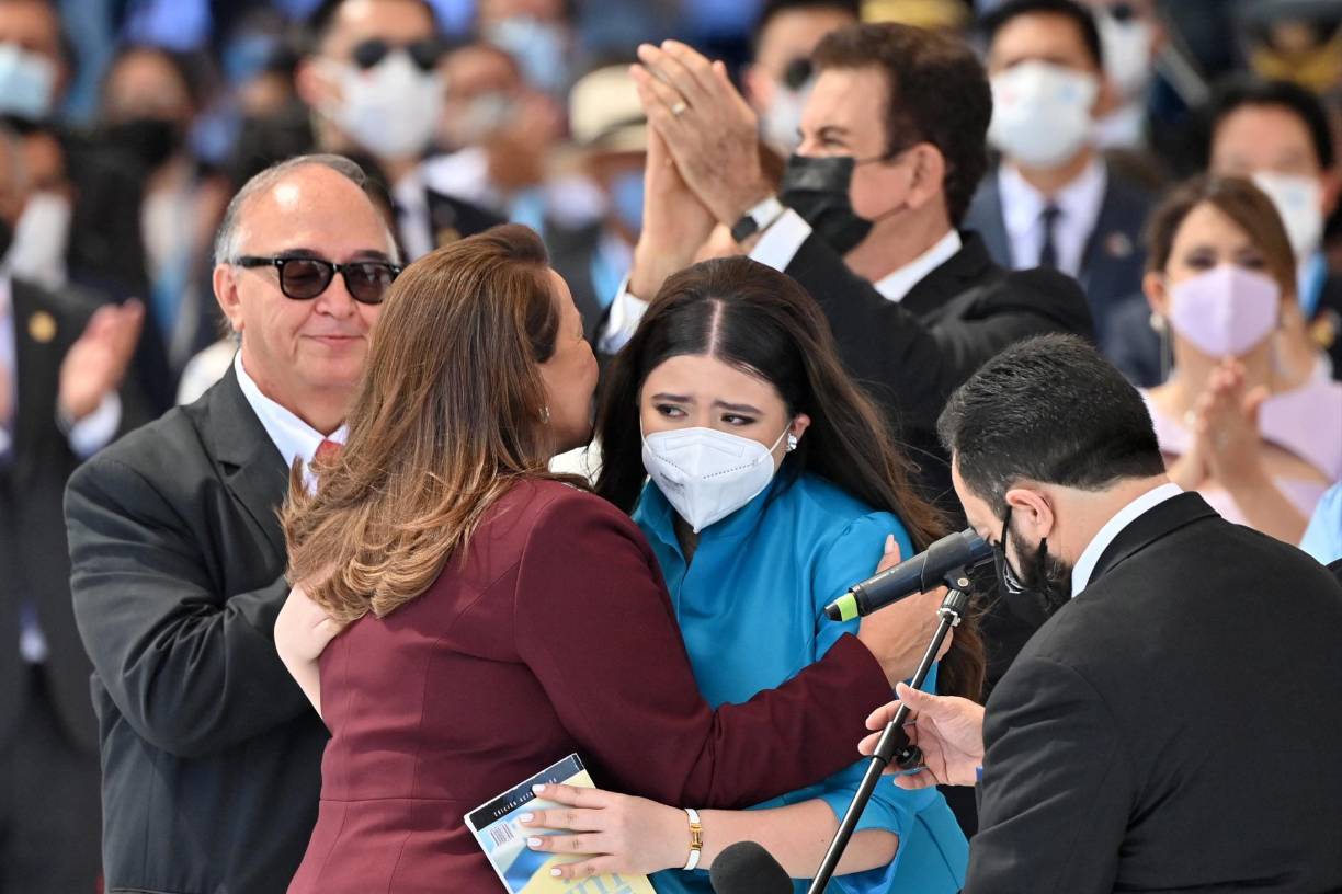 Vestida con un traje azul turquesa, la joven de 17 años, ayudó al presidente del Congreso Luis Redondo a imponer la banda presidencial a la primera mujer presidenta de Honduras.