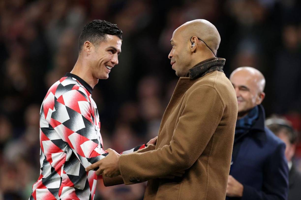 Cristiano Ronaldo saludando al exfutbolista francés Thierry Henry, quien estuvo comentando el partido en el estadio para un canal televisivo.