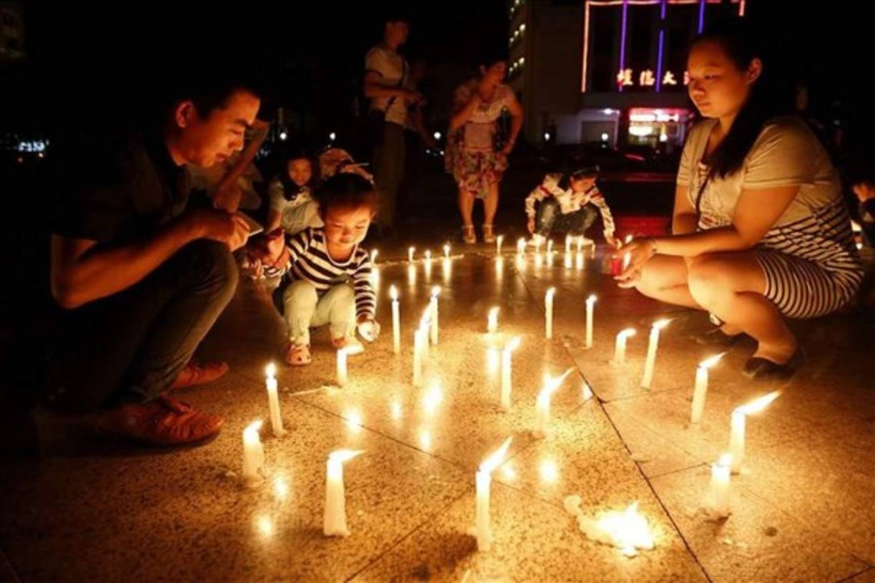 Familiares y amigos de los pasajeros del barco que naufragó en el río Yangzé asistieron ayer a una vigilia en Jianli, China. Eran 456 las personas que viajaban en el 'Estrella Oriental', y tan sólo 14 sobrevivieron a la catástrofe, entre ellas el capitán y el jefe de máquinas. EFE