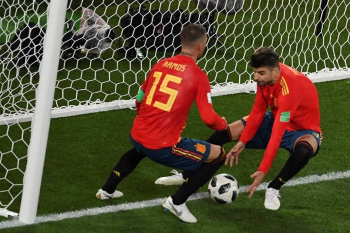 Los defensa de España Gerrard Piqué y Sergio Ramos recogen la pelota tras el 2-2.