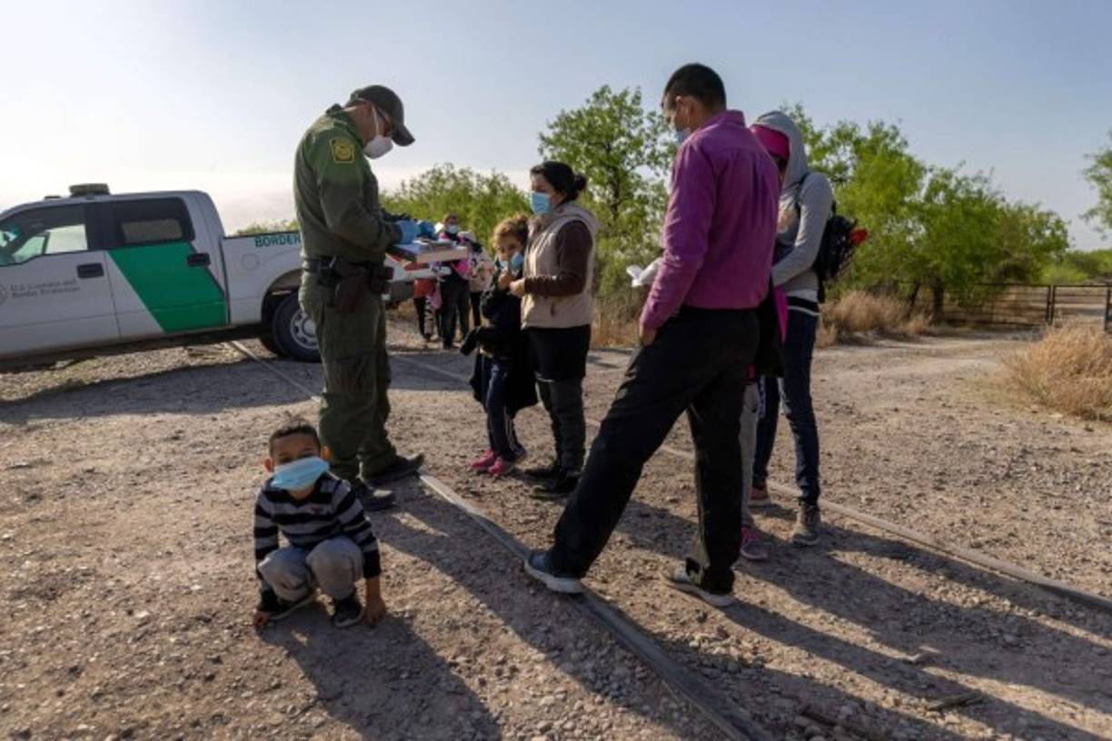 LA JOYA, TEXAS - MARCH 28: A mother and her son wait to climb into a U.S. Border Patrol truck after turning themselves in following their crossing the border from Mexico on March 28, 2021 in La Joya, Texas. The two were part of a group originally from Honduras seeking asylum in the United States. Joe Raedle/Getty Images/AFP<br/><br/>== FOR NEWSPAPERS, INTERNET, TELCOS & TELEVISION USE ONLY ==<br/><br/>