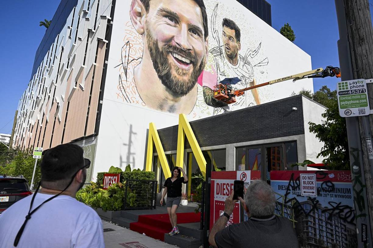 El artista ya terminó una parte del mural, la cara sonriente de la estrella, y se dedica ahora a la otra: el futbolista de cuerpo entero con la camiseta de su nuevo equipo. Una labor minuciosa que realiza cada mañana con spray de pintura, bajo una sombrilla que lo protege a duras penas del calor.