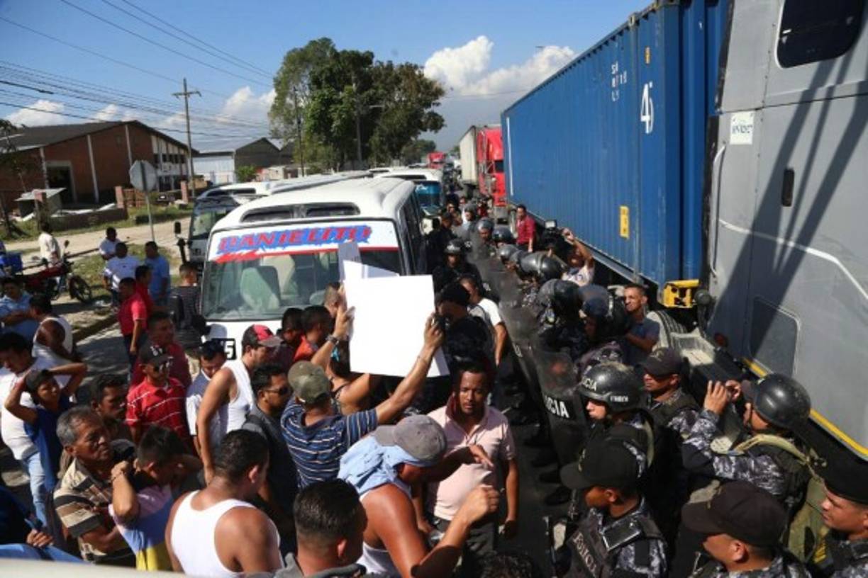 Ayudantes y motoristas de las unidades de transporte Impala y Caribe en el bulevar del norte de San Pedro Sula.