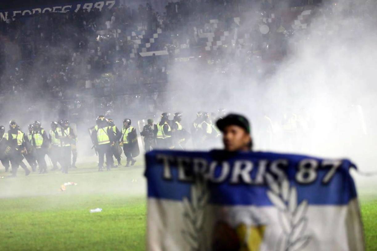 Una multitud saltó al campo e inició un enfrentamiento con los agentes de la policía que respondieron utilizando gases lacrimógenos en el verde césped y en las gradas. 