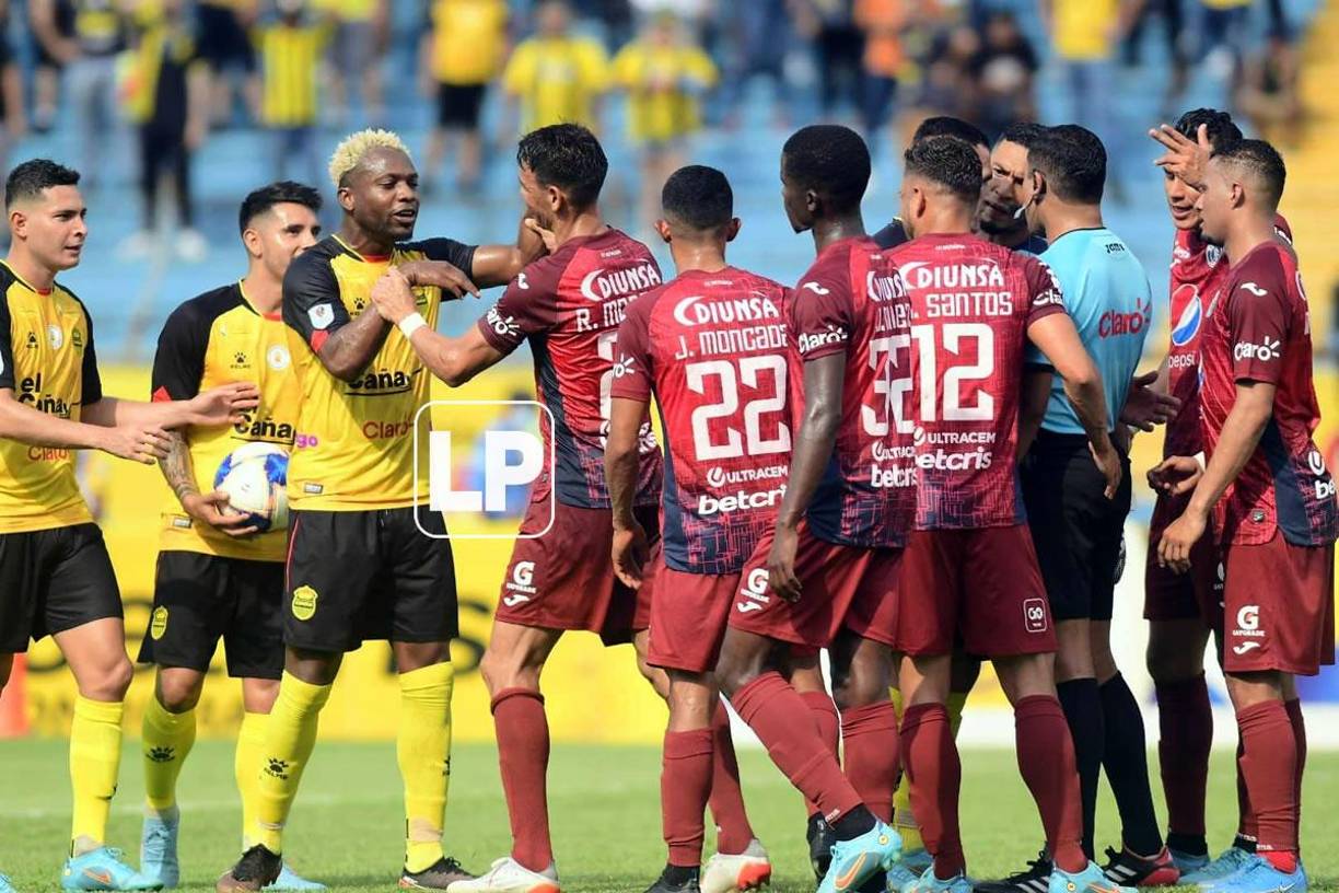 Jugadores de Real España y Motagua discuten tras la decisión del árbitro de marcar el penal.