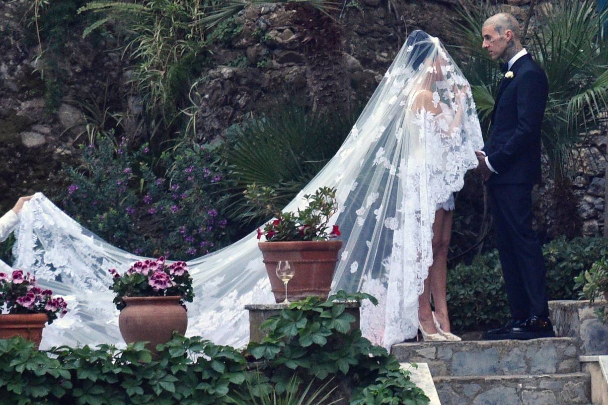 La pareja, que se comprometió en octubre, se dio el ‘sí quiero’ en la antigua fortaleza Castello Brown de Portofino el domingo, y Kourtney optó por un impresionante vestido corto de encaje blanco de la firma Dolce Gabanna, que combinó con un velo más tradicional adornado con un diseño religioso.