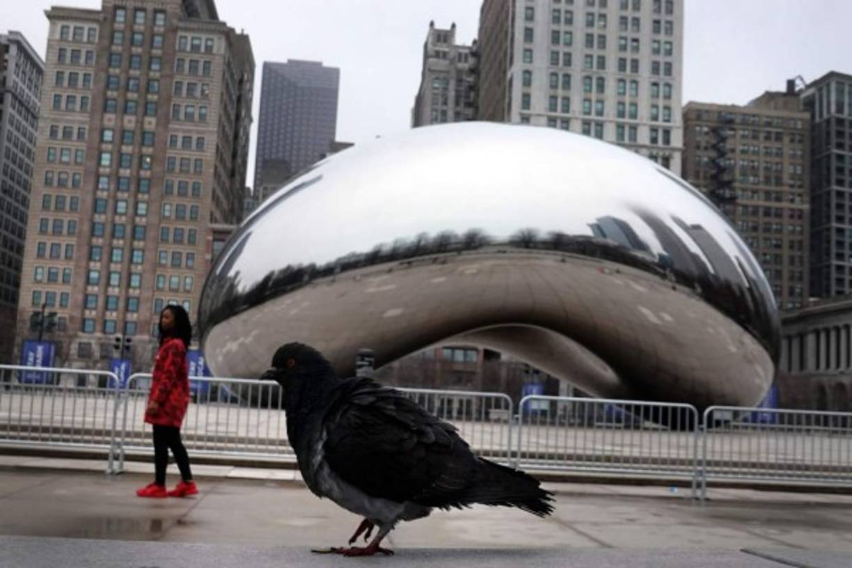 Una barricada rodea la escultura de Cloud Gate en el Millennium Park de en Chicago, Illinois. La escultura, una de las atracciones turísticas más visitadas de la ciudad que invita a una experiencia práctica, se ha cerrado al público mientras la ciudad intenta controlar la propagación de Covid-19. Foto AFP