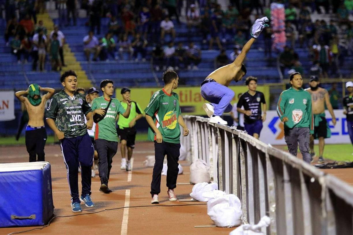 Aficionados saltaron las vallas publicitarias para entrar a la cancha del estadio Olímpico.
