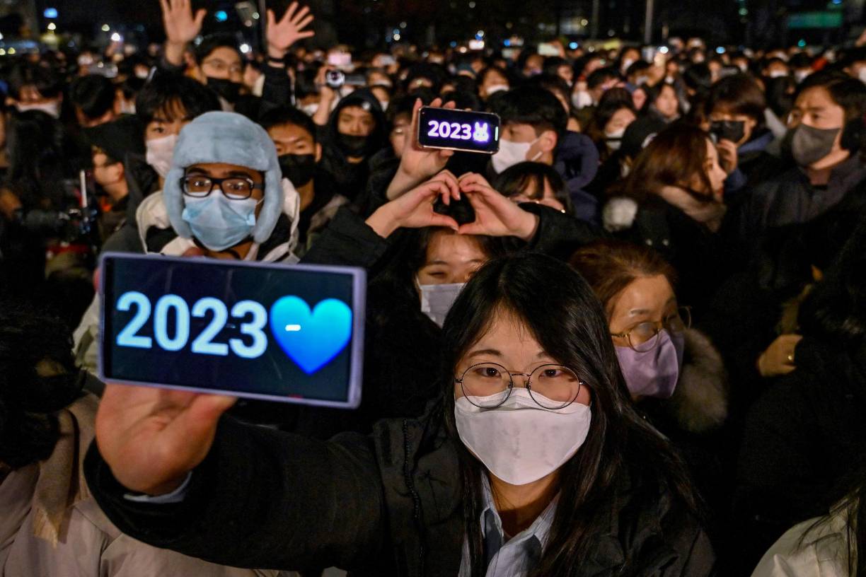 <b>Corea del Sur</b>La gente celebra después de la medianoche durante un evento de cuenta regresiva para conmemorar el Año Nuevo en el pabellón Bosingak en el centro de Seúl el 1 de enero de 2023.