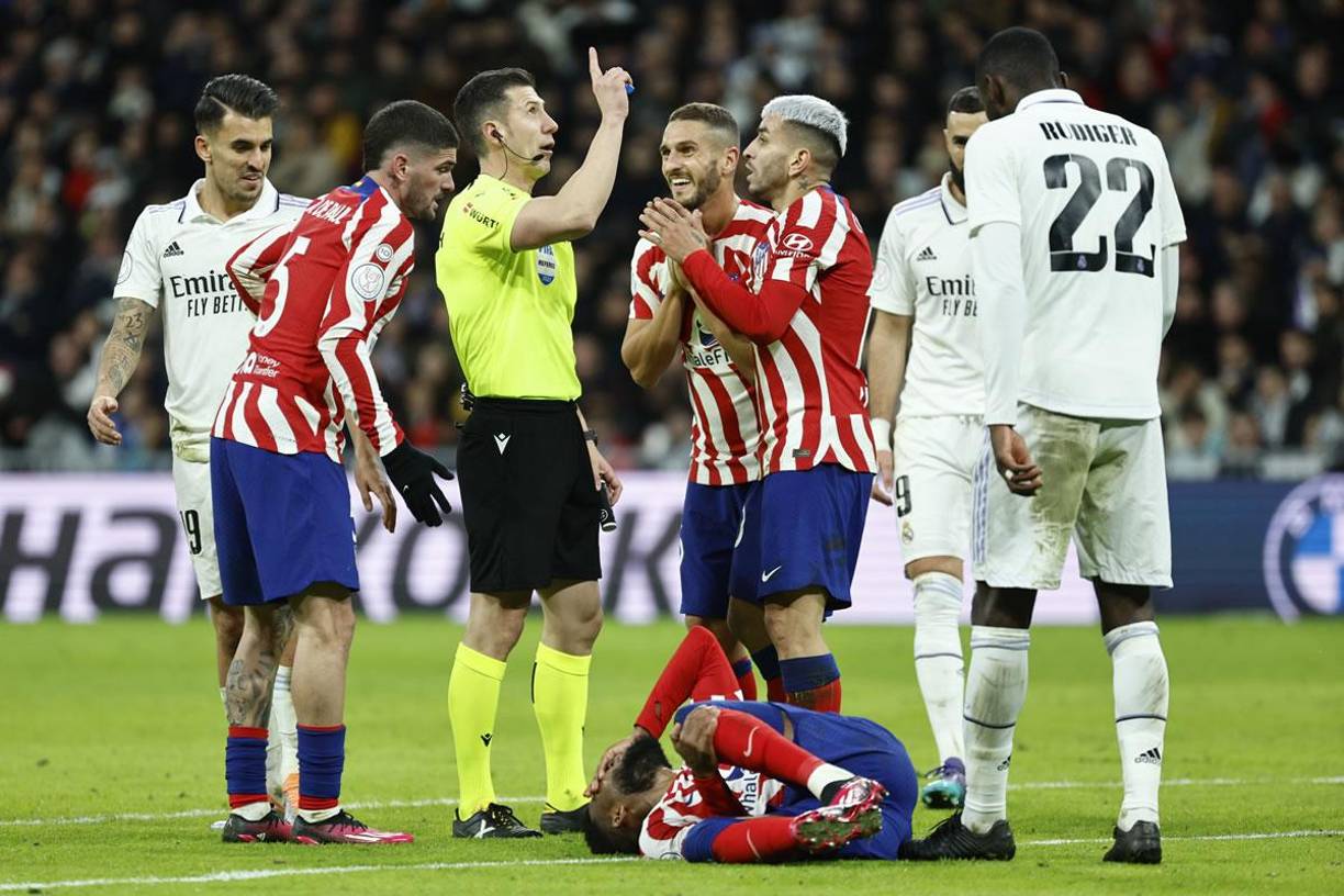 Jugadores del Atlético de Madrid le reclaman y le piden la segunda cartulina amarilla a Dani Ceballos después de otra falta que hizo en el borde del área del Real Madrid.