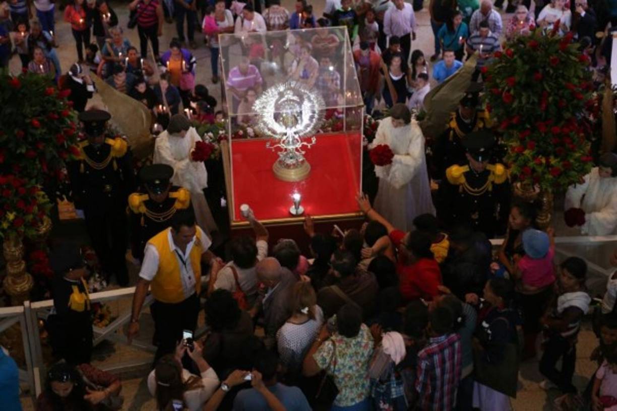 Los fieles se congregan alrededor de la urna que contiene la imagen de Suyapa y le encienden velas.