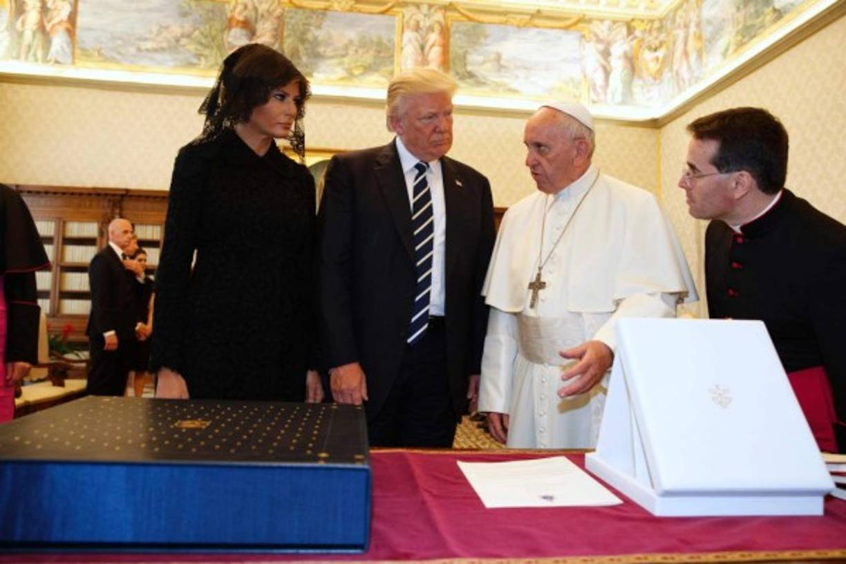 Pope Francis (2ndR) exchanges gifts with US President Donald Trump (2ndL) and US First Lady Melania Trump during a private audience at the Vatican on May 24, 2017. US President Donald Trump met Pope Francis at the Vatican today in a keenly-anticipated first face-to-face encounter between two world leaders who have clashed repeatedly on several issues. / AFP PHOTO / POOL / Evan Vucci