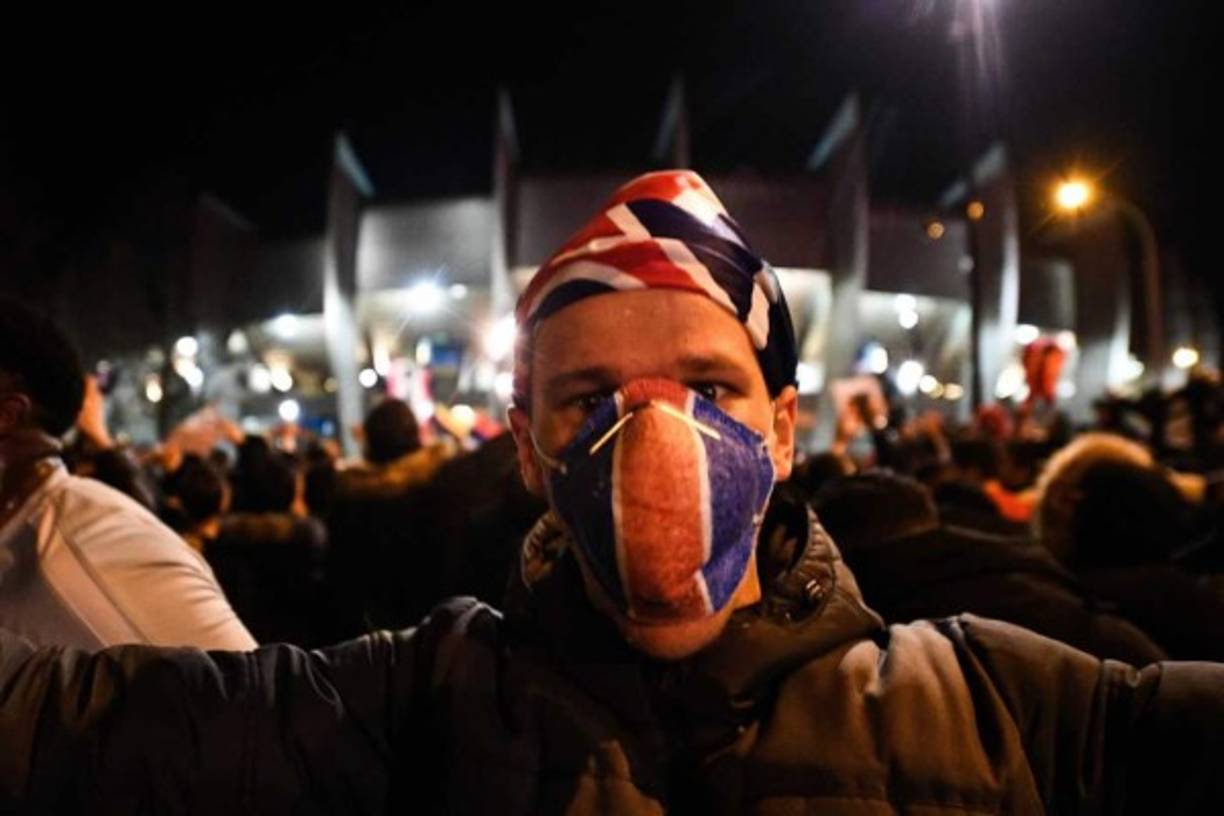 Un aficionado del PSG cubriéndose la boca con una mascarilla por el coronavirus en las afueras del Parque de los Príncipes.