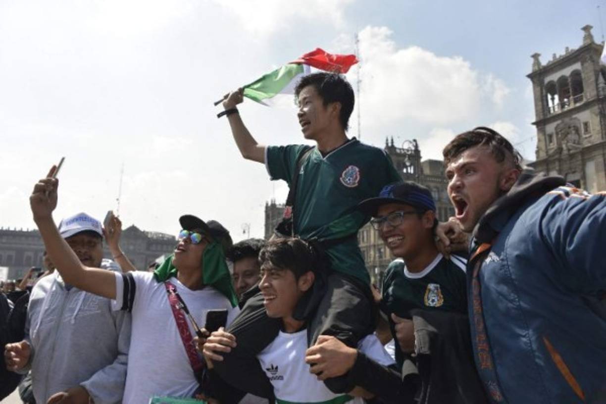 Un coreano es cargado por los aficionados mexicanos en el Zócalo.