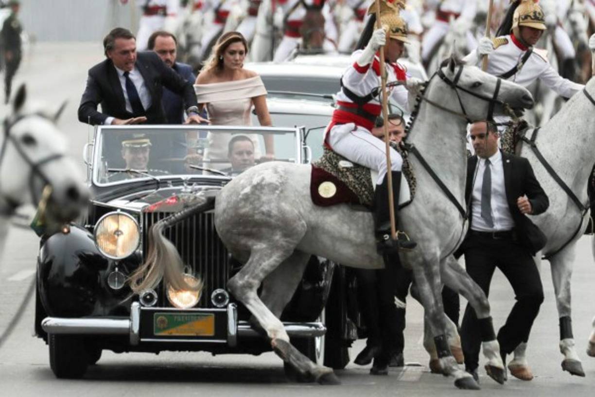 El nuevo presidente brasileño, Jair Bolsonaro (i), y su esposa Michele (2-d), observan uno de los caballos de la guardia presidencial que sufre un percance durante un corto recorrido mientras se dirige al Palacio de Planalto, donde recibió la banda presidencial de manos de su antecesor, Michel Temer, en Brasilia (Brasil). <br/><br/>
