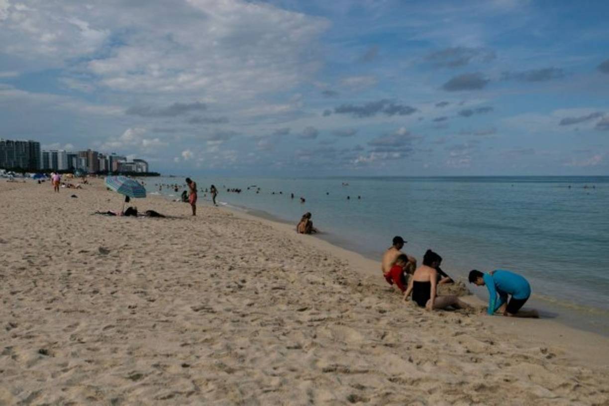 Beachgoers are seen on the shore during a hurricane alert for this weekend in South Miami Beach on August 29, 2019. - Florida residents stocked up on bottled water, groceries and gasoline Thursday as Hurricane Dorian gathered strength and churned across the Atlantic Ocean on a collision course with the southern US state. Weather forecasters said Dorian, currently a Category 1 storm -- the lowest on a five-level scale -- could make landfall as a dangerous Category 4 hurricane. (Photo by Eva Marie UZCATEGUI / AFP)
