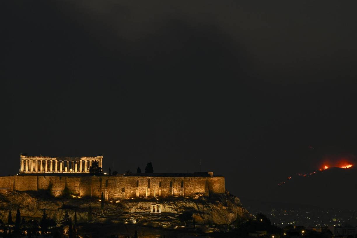 Las autoridades griegas urgieron el martes a evacuar un distrito periférico de Atenas ante el avance de un devastador <b>incendio</b> forestal, el segundo de la actual temporada estival en el país, que dejó 20 muertos en dos días.