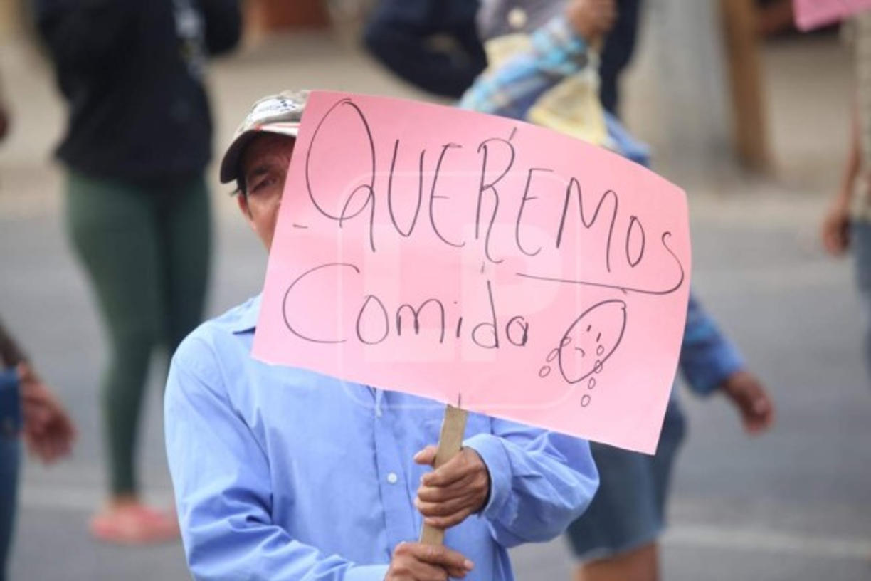 Pancartas con leyendas como 'Queremos comida', 'Tengo hambre', 'Una ayuda por favor' enmudecen a la población que hace sus trámites según último dígito de la cédula.